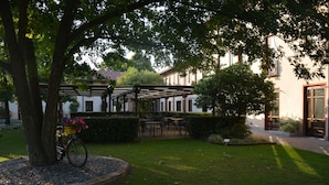 A courtyard with a bicycle, outdoor seating, and a pergola. - Romantic Hotel Furno (San Francesco al Campo)