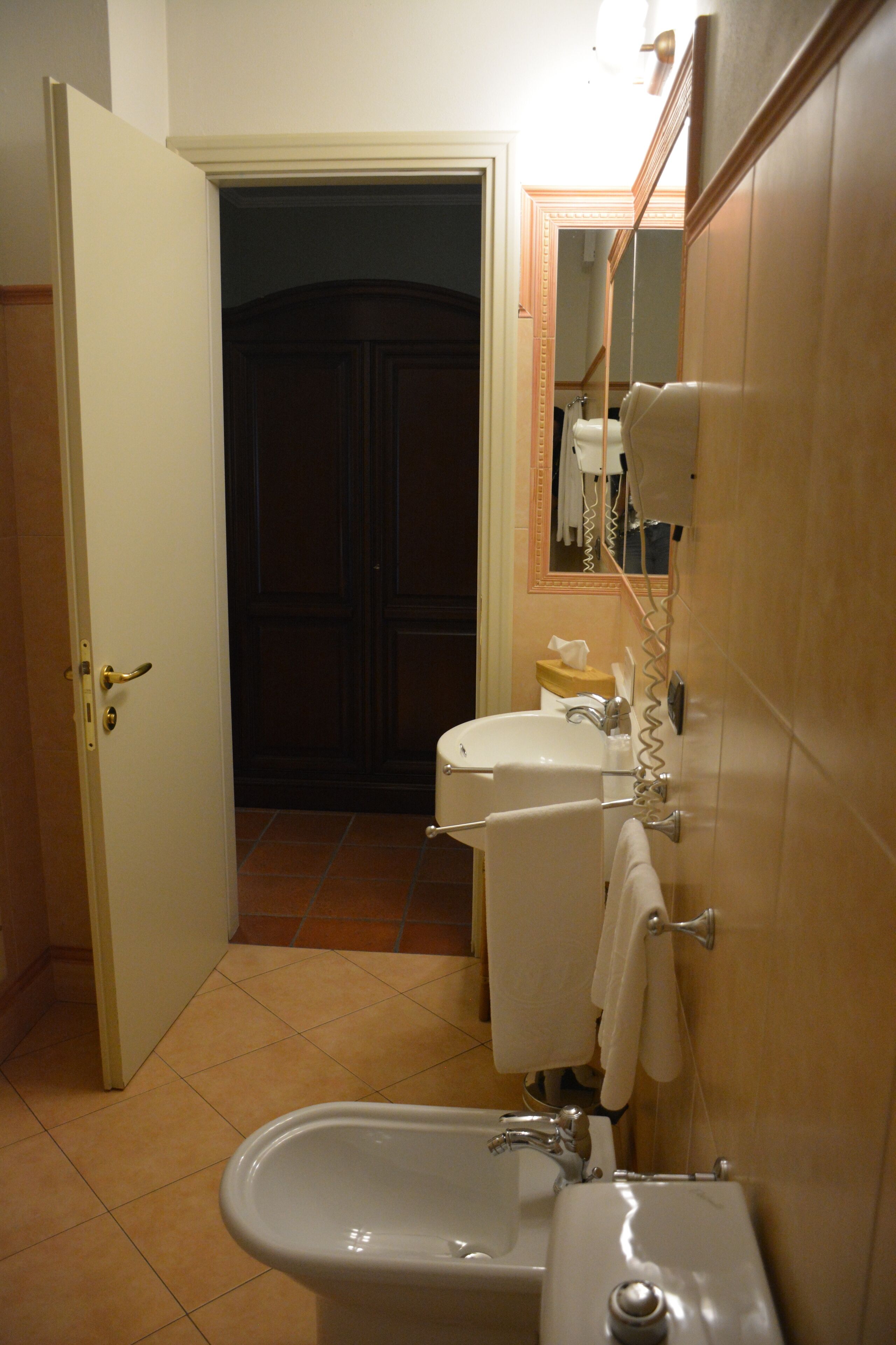 A bathroom with a sink, toilet, and bidet.