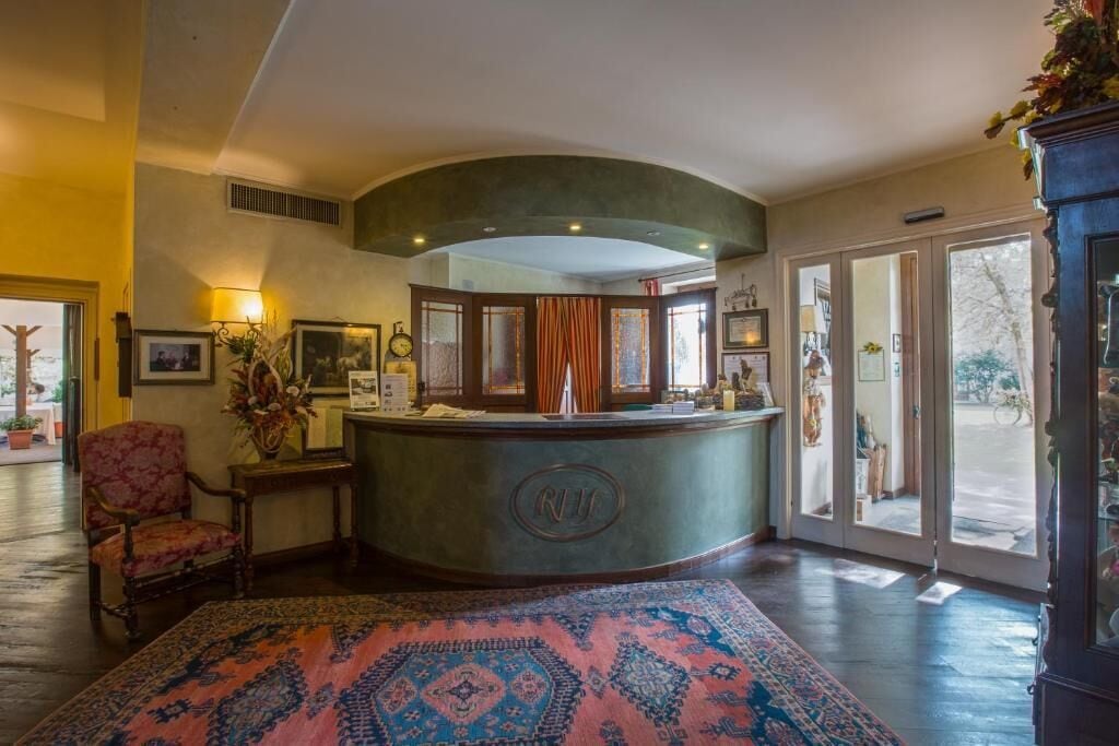A reception area with a curved counter, a chair, and a patterned rug.