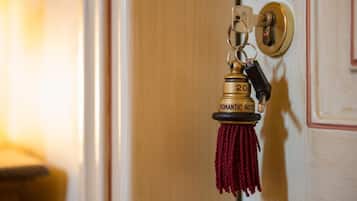A keychain with a brass tag labeled "Romantic Hotel" and the number "20" on a door handle.