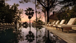 A poolside area with lounge chairs and a reflection of trees. - Hotel Alberi del Paradiso (Cefalù)