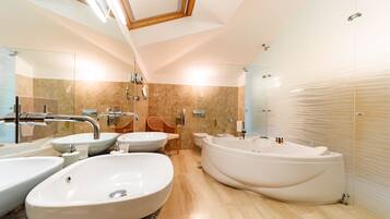 Ein modernes Badezimmer mit drei Waschbecken, einer Badewanne und einem Spiegel.