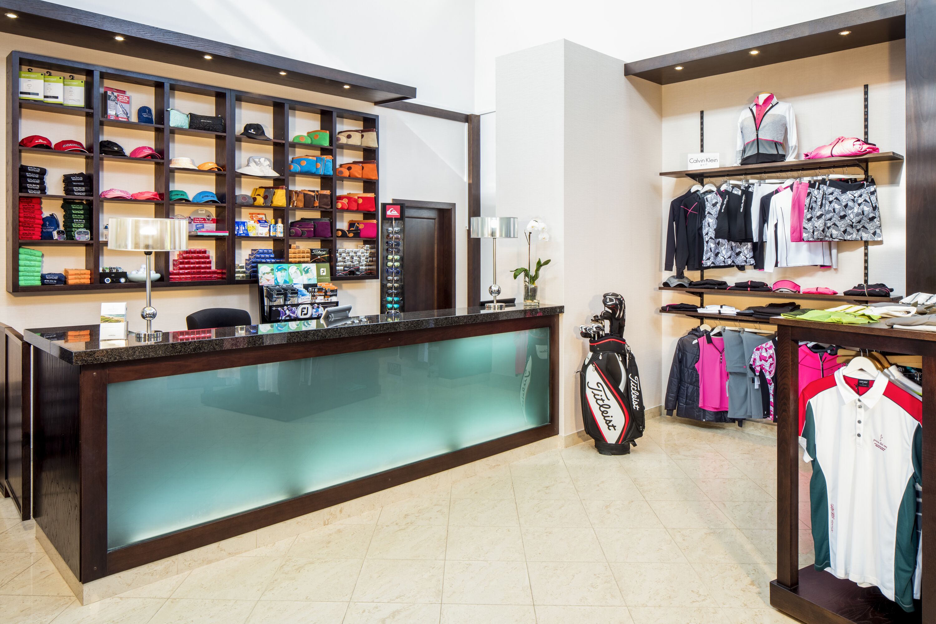 A well-organized retail space with shelves of hats, golf bags, and clothing racks.