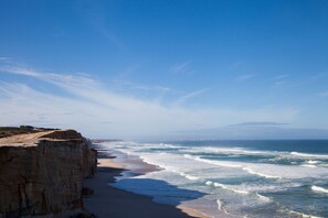A coastal landscape with a cliff and beach. - The Village Praia d'El Rey Golf & Beach Resort (Obidos)
