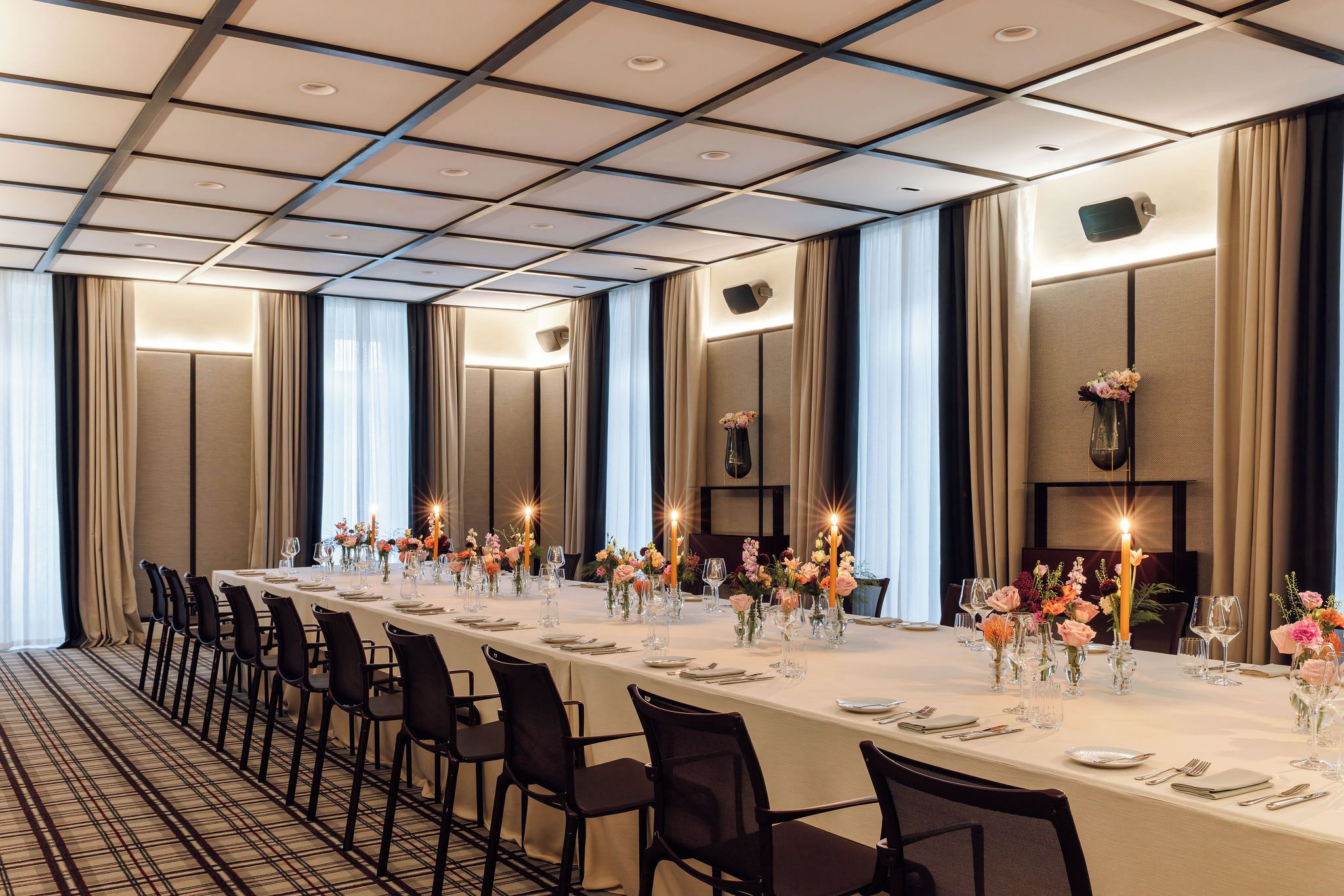 A long banquet table set for a formal event, with chairs aligned on both sides.