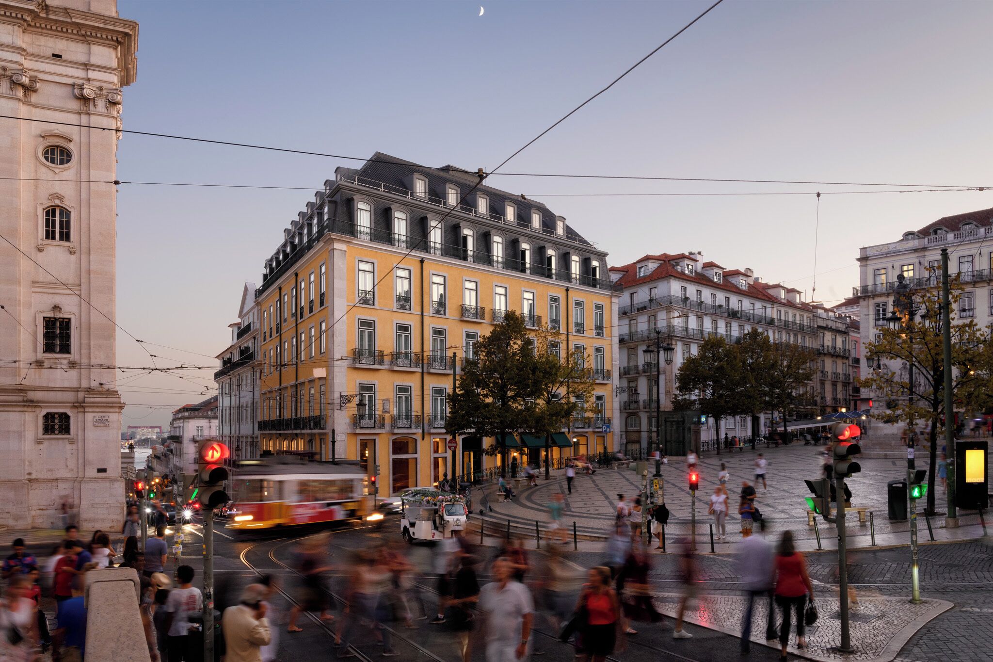 Um edifício histórico com vários andares, grandes janelas e localização de destaque na esquina.