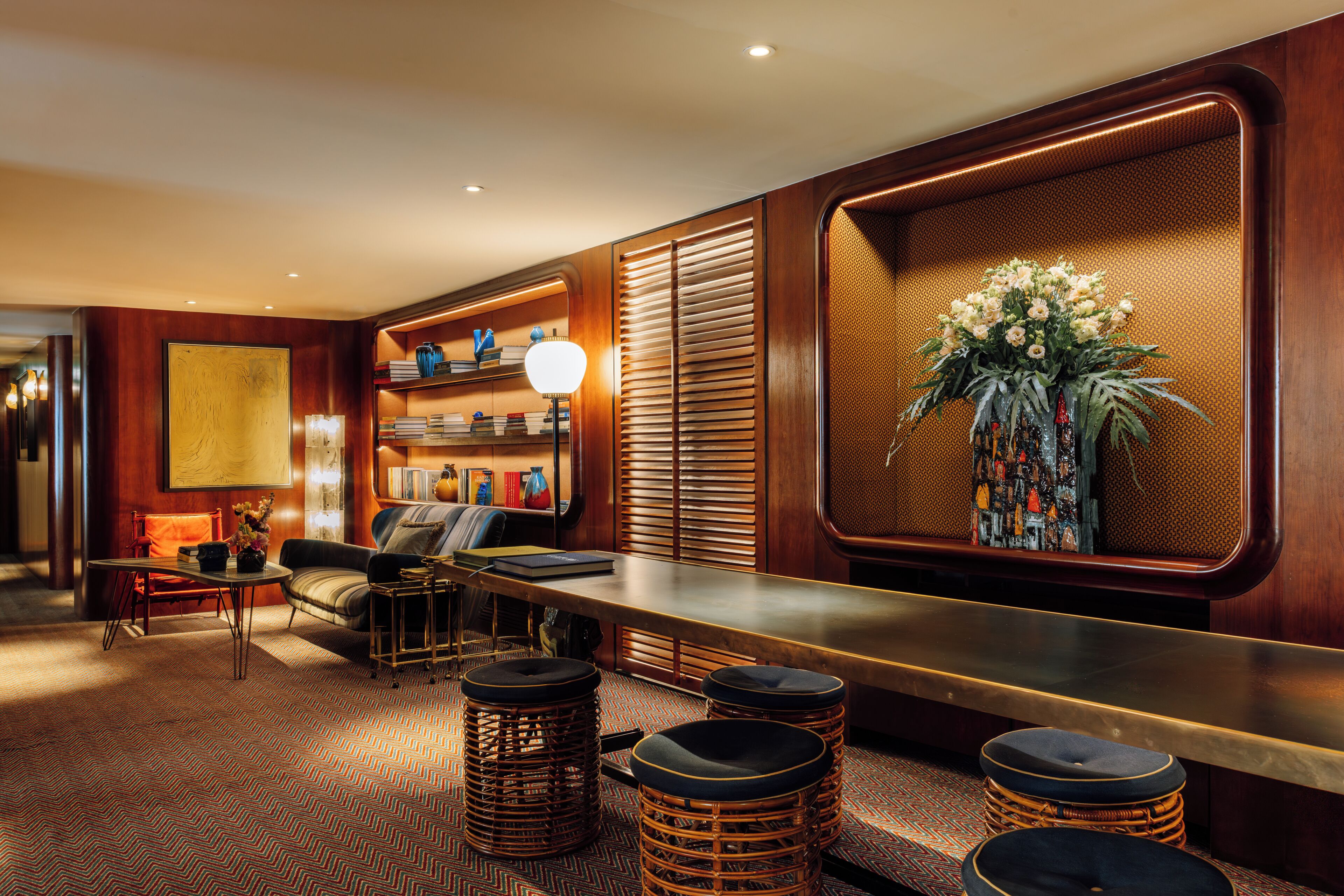 A bar area with a long counter, stools, and a decorative plant.