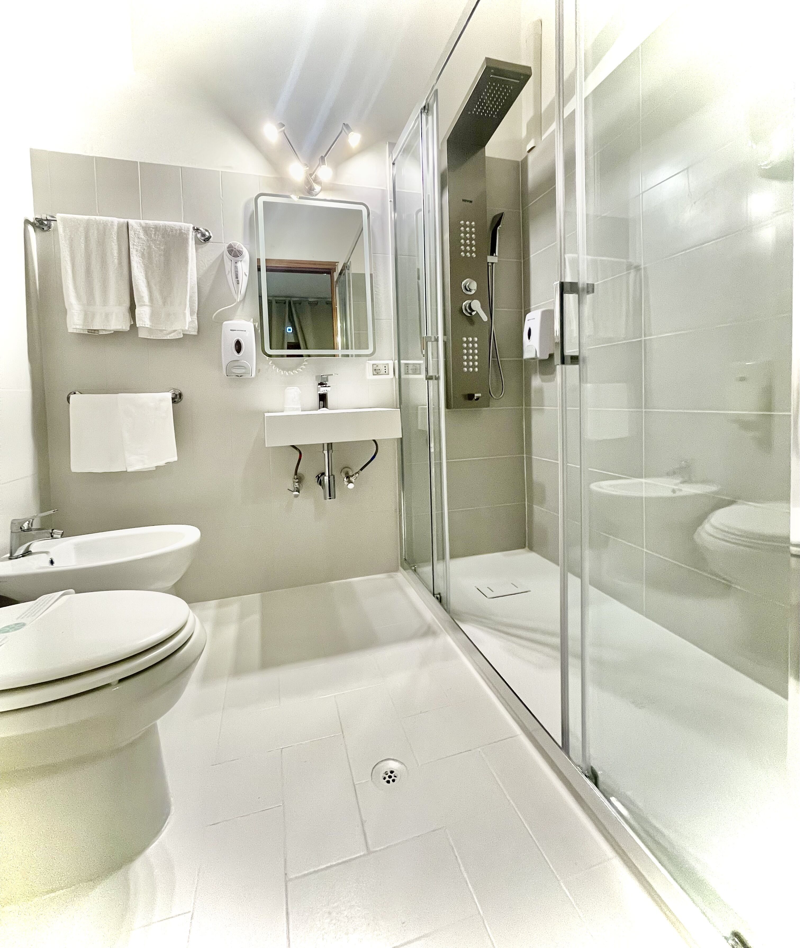 Une salle de bain moderne avec une douche à parois de verre, un lavabo et des toilettes.