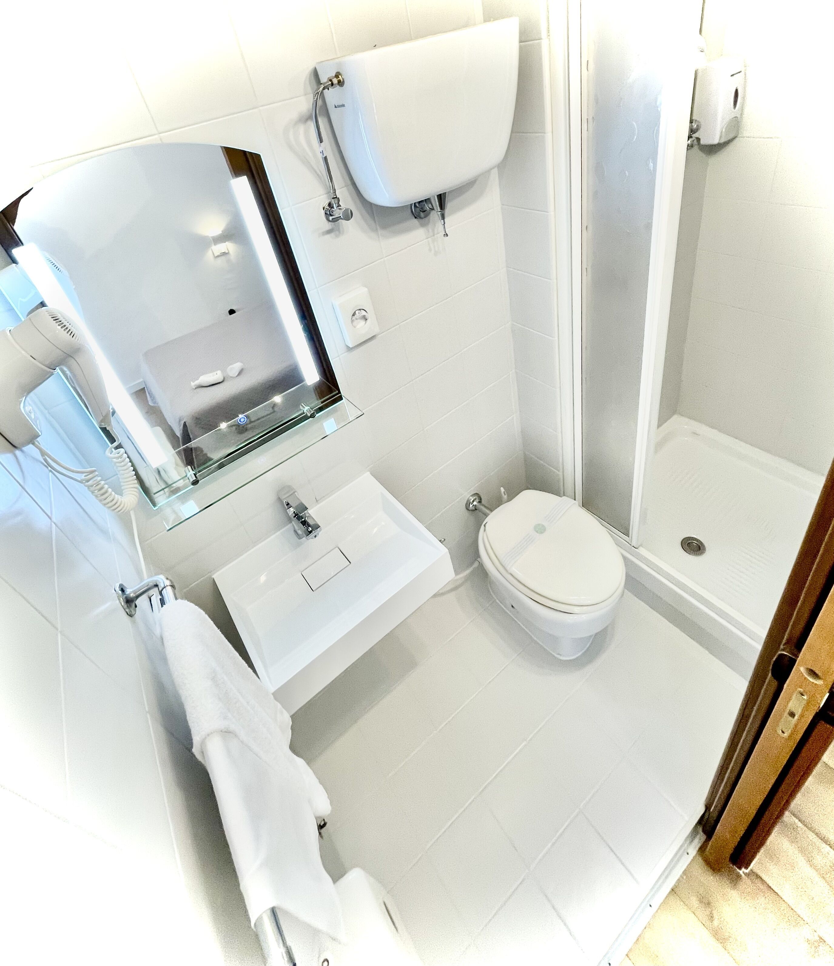 Une salle de bain moderne avec une douche à parois de verre, des toilettes, un lavabo et un porte-serviettes.