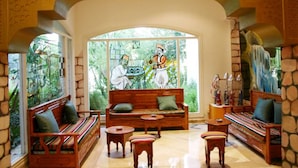 Ampla sala de estar com uma grande janela, móveis de madeira e um mural na parede.