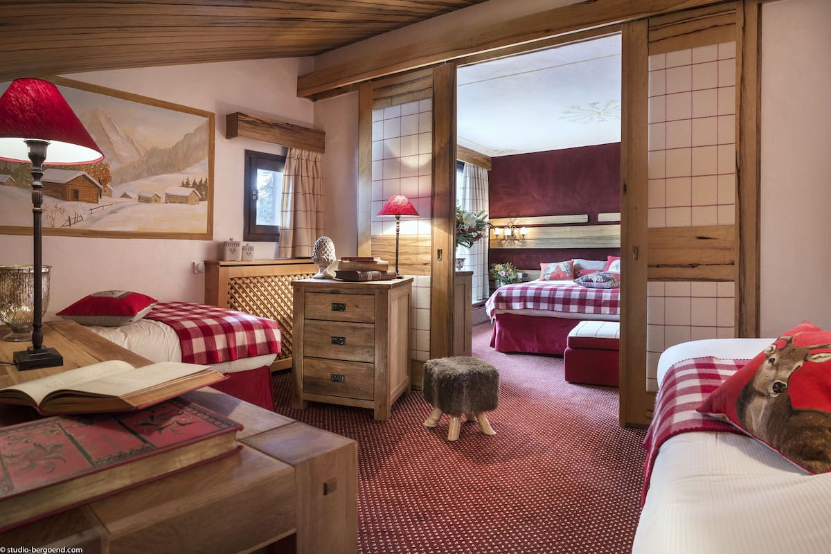 Une chambre de style japonais traditionnel, avec un sol recouvert de tatamis, un futon servant de lit, une commode en bois et un tableau représentant un paysage enneigé.