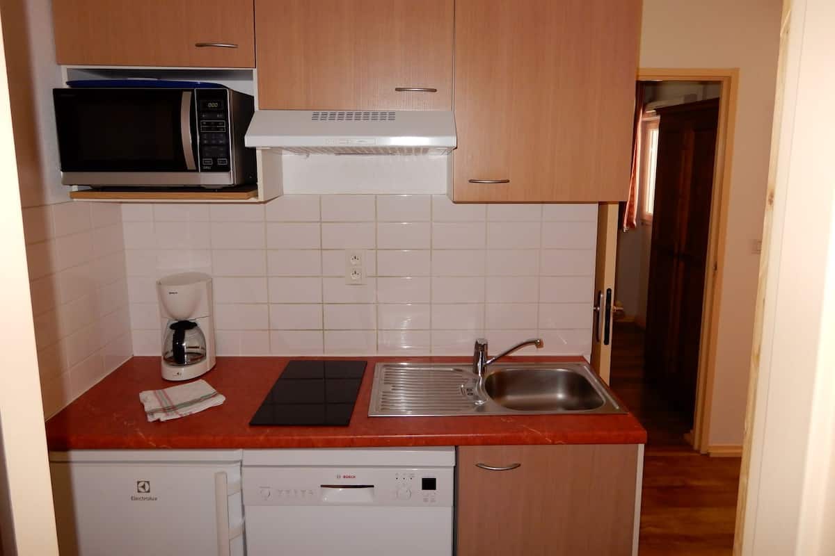 Cocina compacta con microondas, cafetera y lavavajillas.