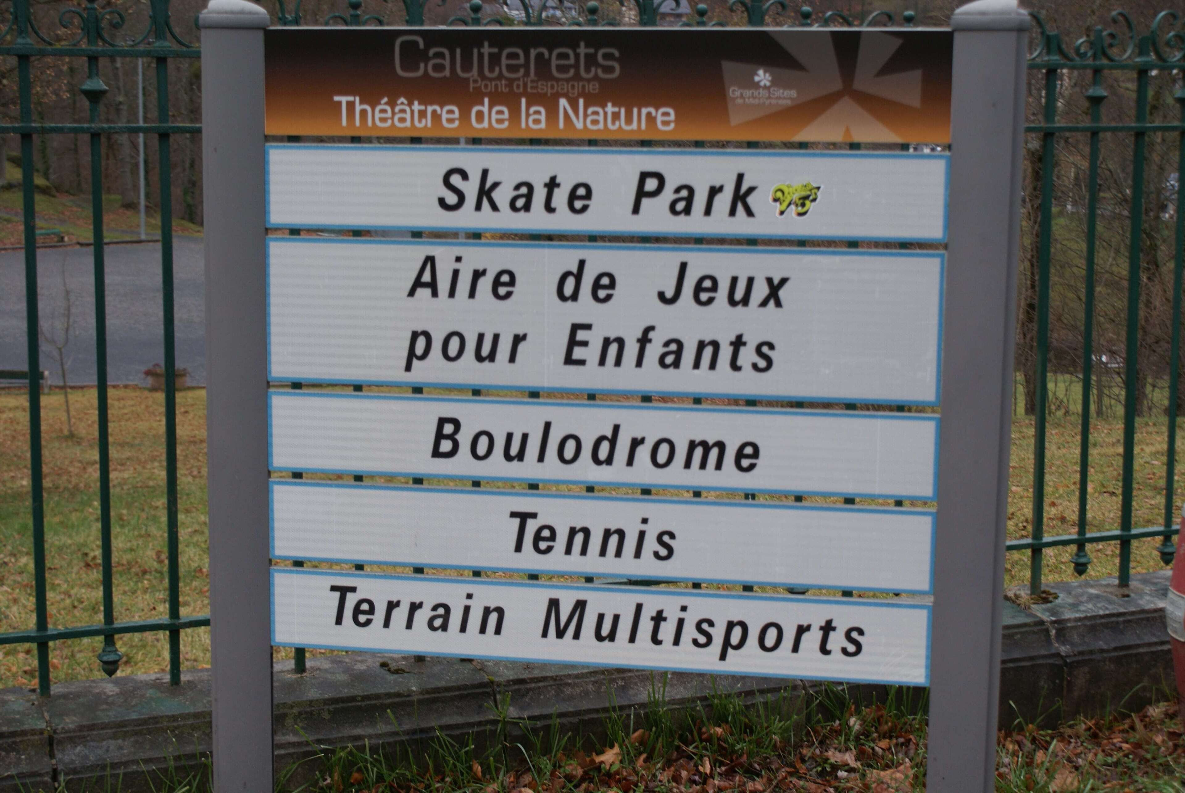 A sign listing amenities including a skate park, children's play area, bowling alley, tennis court, and multisports terrain.