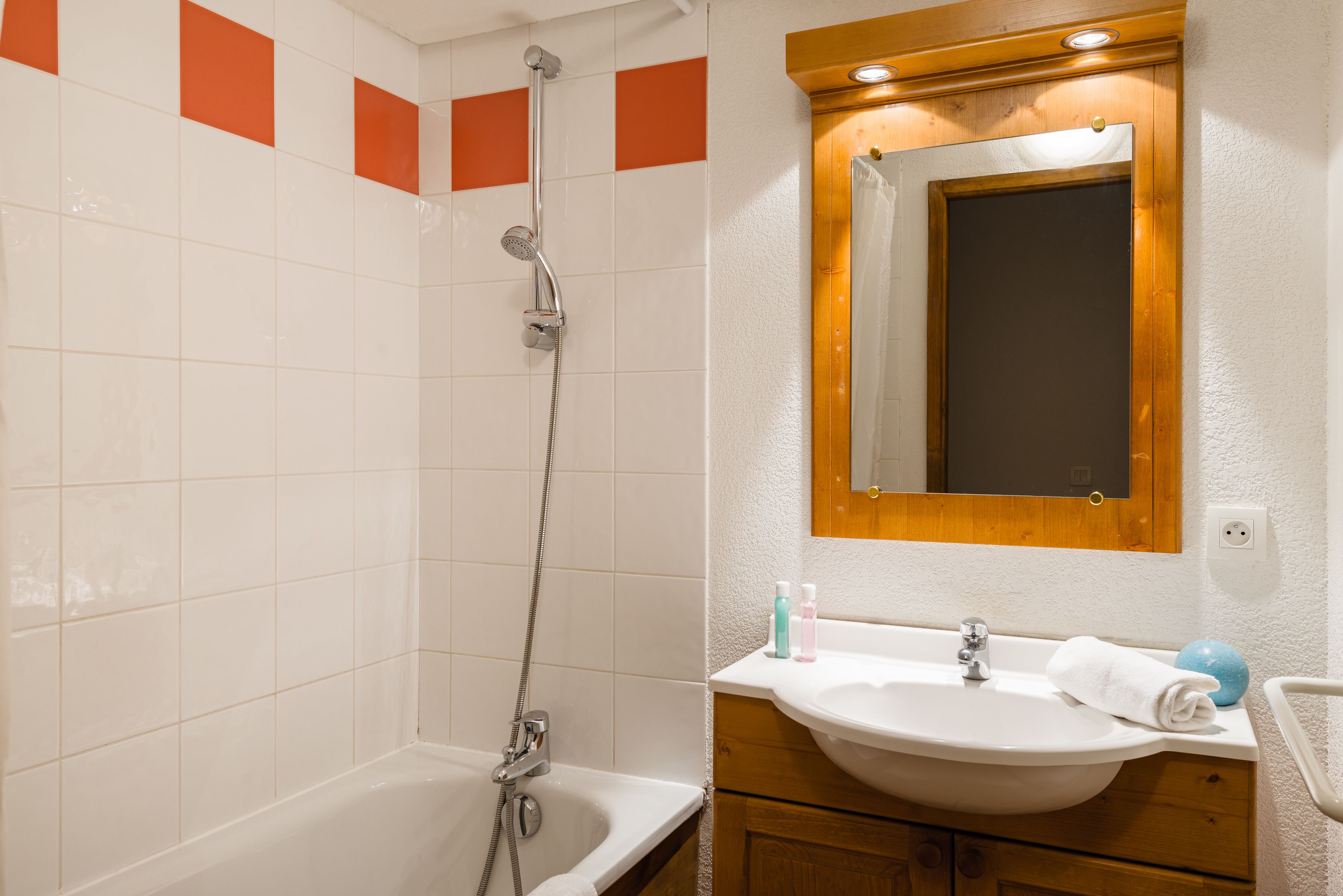 Une salle de bain avec une baignoire, une douche, un lavabo et un miroir.