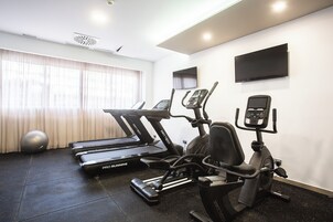 A gym with treadmills, an elliptical, and a stationary bike.
