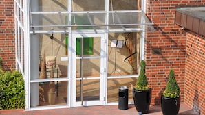 A building entrance with a glass door and a metal awning.