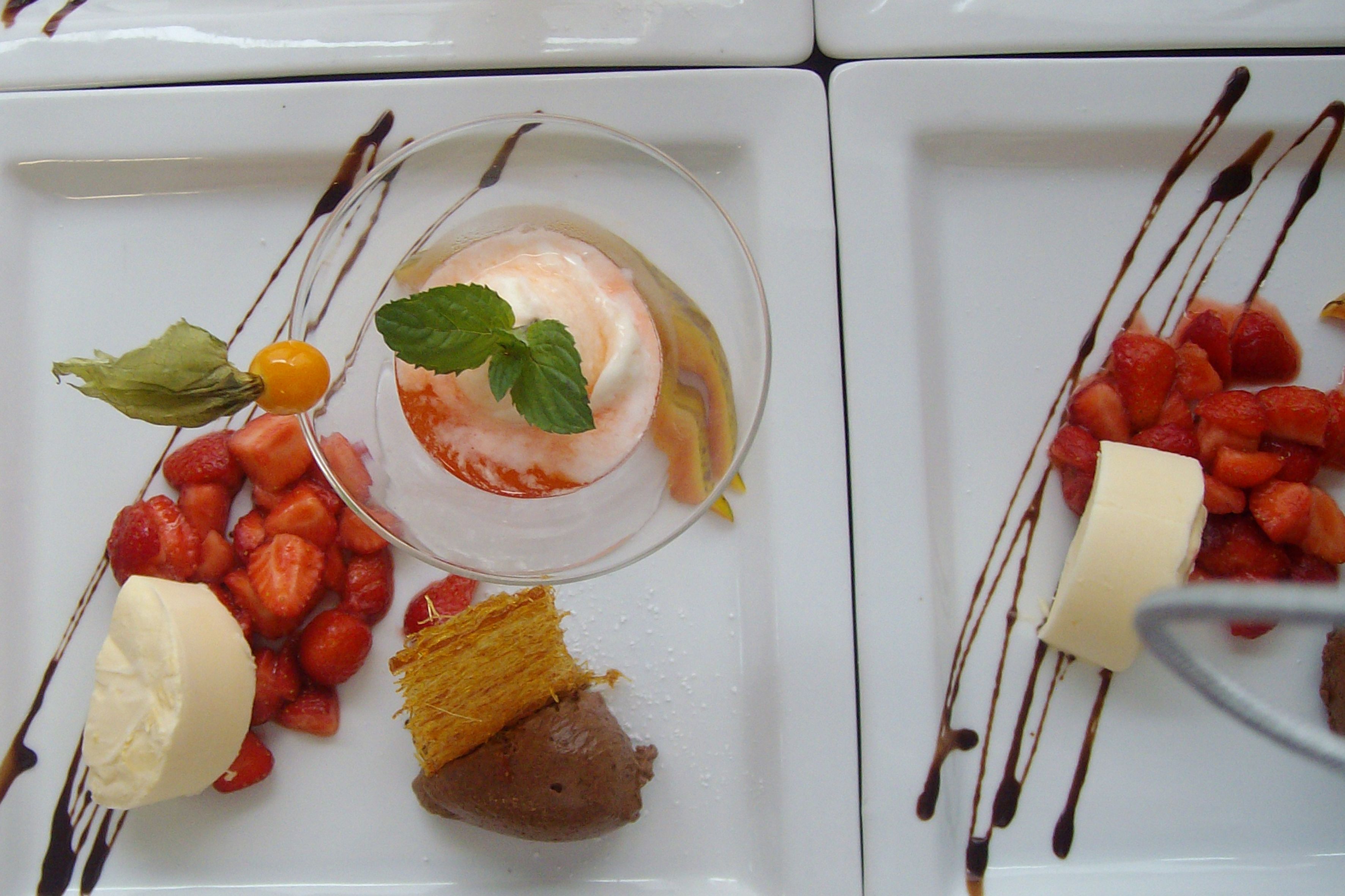 A dessert plate with strawberries, a scoop of ice cream, and a piece of cake.