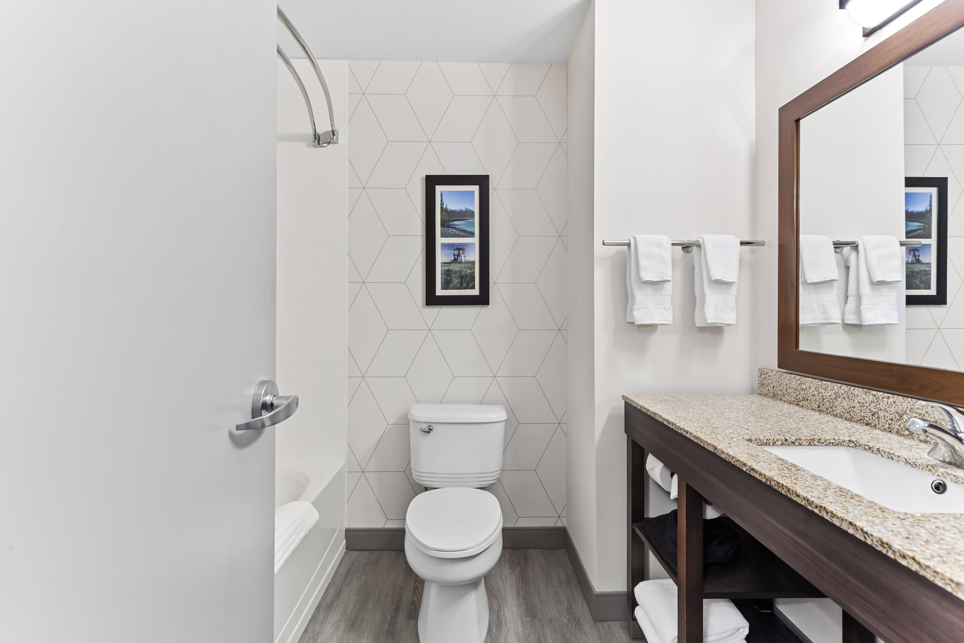A modern bathroom with a toilet, sink, and shower.