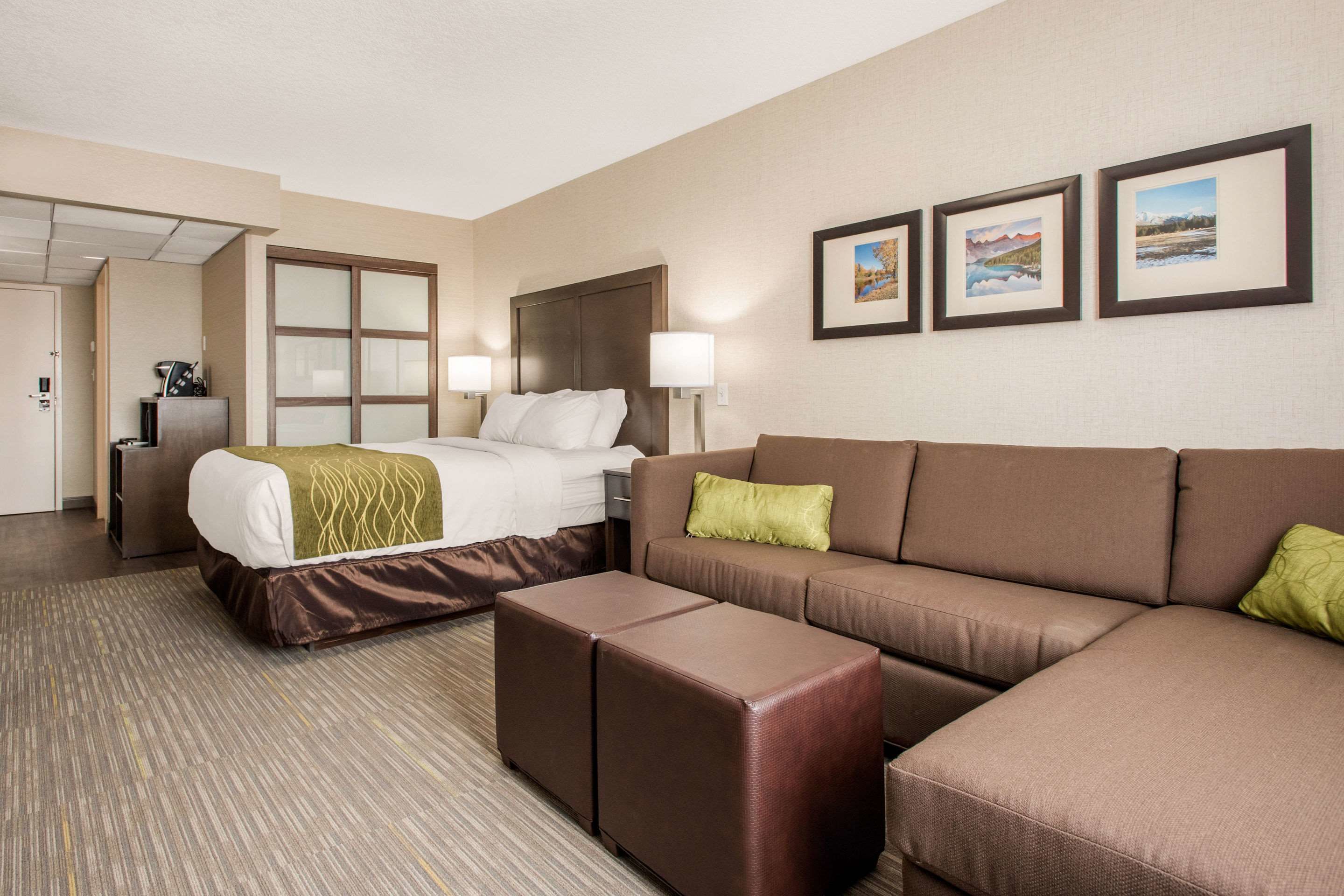 Une chambre d’hôtel avec un lit, un canapé, une table basse et un bureau.