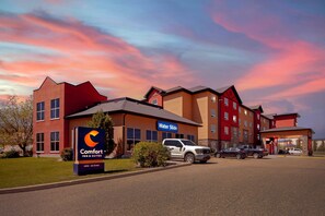 A Comfort Inn & Suites hotel with a parking lot, a sign indicating the Water Slide, and a clear sky. - Comfort Inn & Suites Red Deer North (Red Deer)