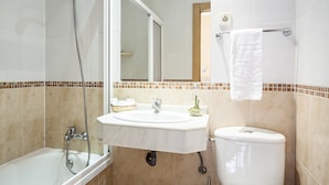 A bathroom with a bathtub, a sink, and a toilet. - INTER Puerta del Sol - Auto Check-in (Madrid)