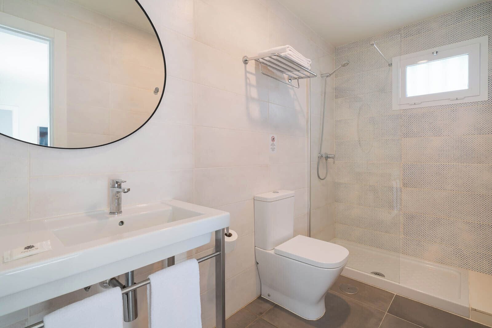 Un baño con lavamanos, inodoro y ducha.