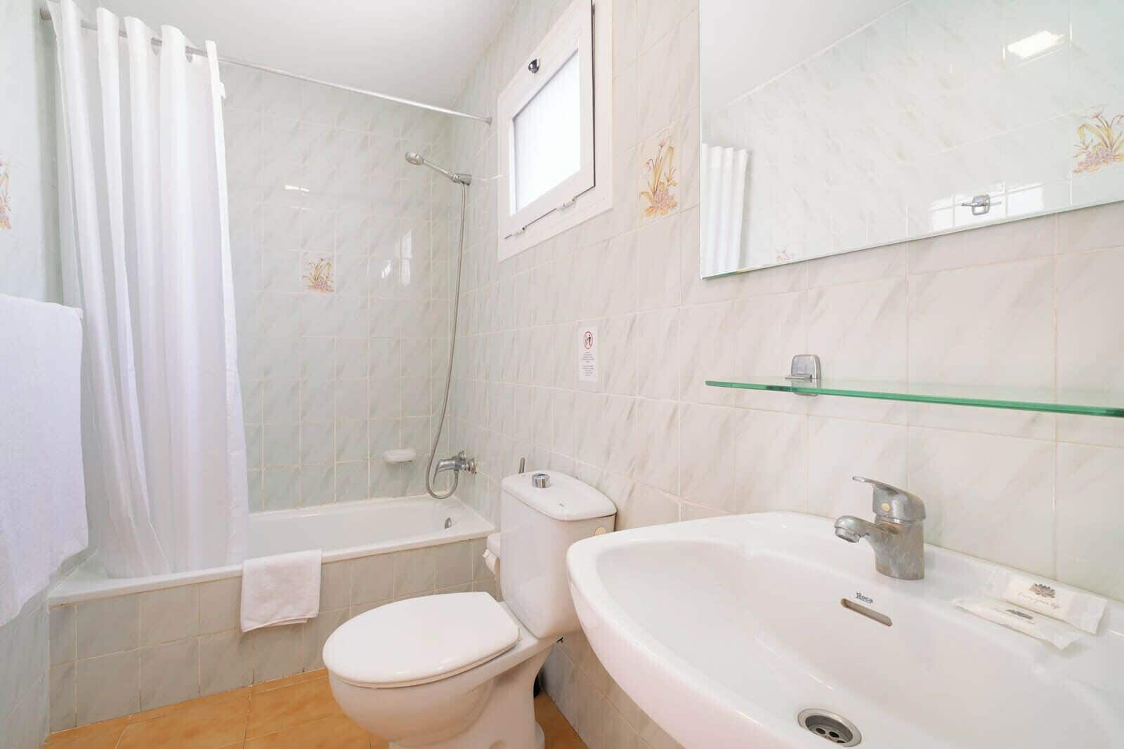 A bathroom with a bathtub, toilet, and sink.