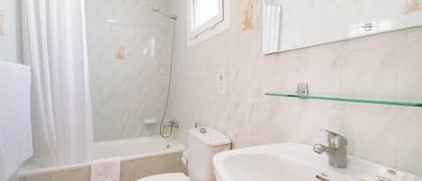 A bathroom with a bathtub, toilet, and sink.