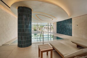 Una piscina al aire libre, sillones reclinables de piscina