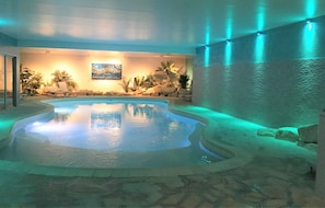 Una piscina cubierta, tumbonas