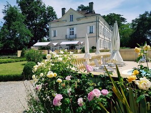 Een groot gebouw met een tuin en een terras.