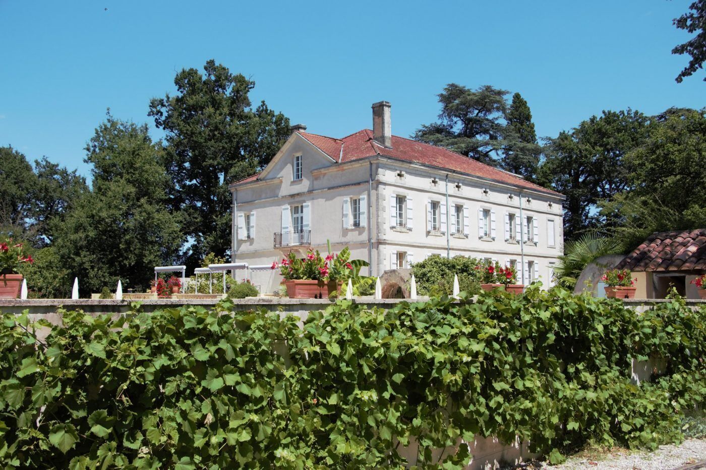 A large, two-story building with a red-tiled roof and multiple windows.