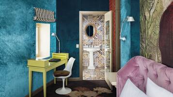 Una habitación con pared color aguamarina, escritorio amarillo, silla blanca, sofá púrpura y alfombra estampada.