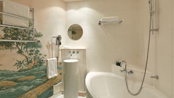Un baño con bañera, lavabo, toallero, espejo y ducha.