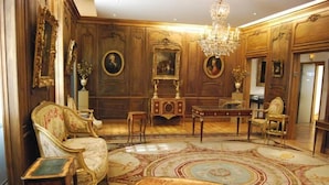 A luxurious room with ornate wood paneling, a grand chandelier, and classic furniture. - Hôtel du Petit Moulin, Haute Couture hotel by Lacroix (Paris)