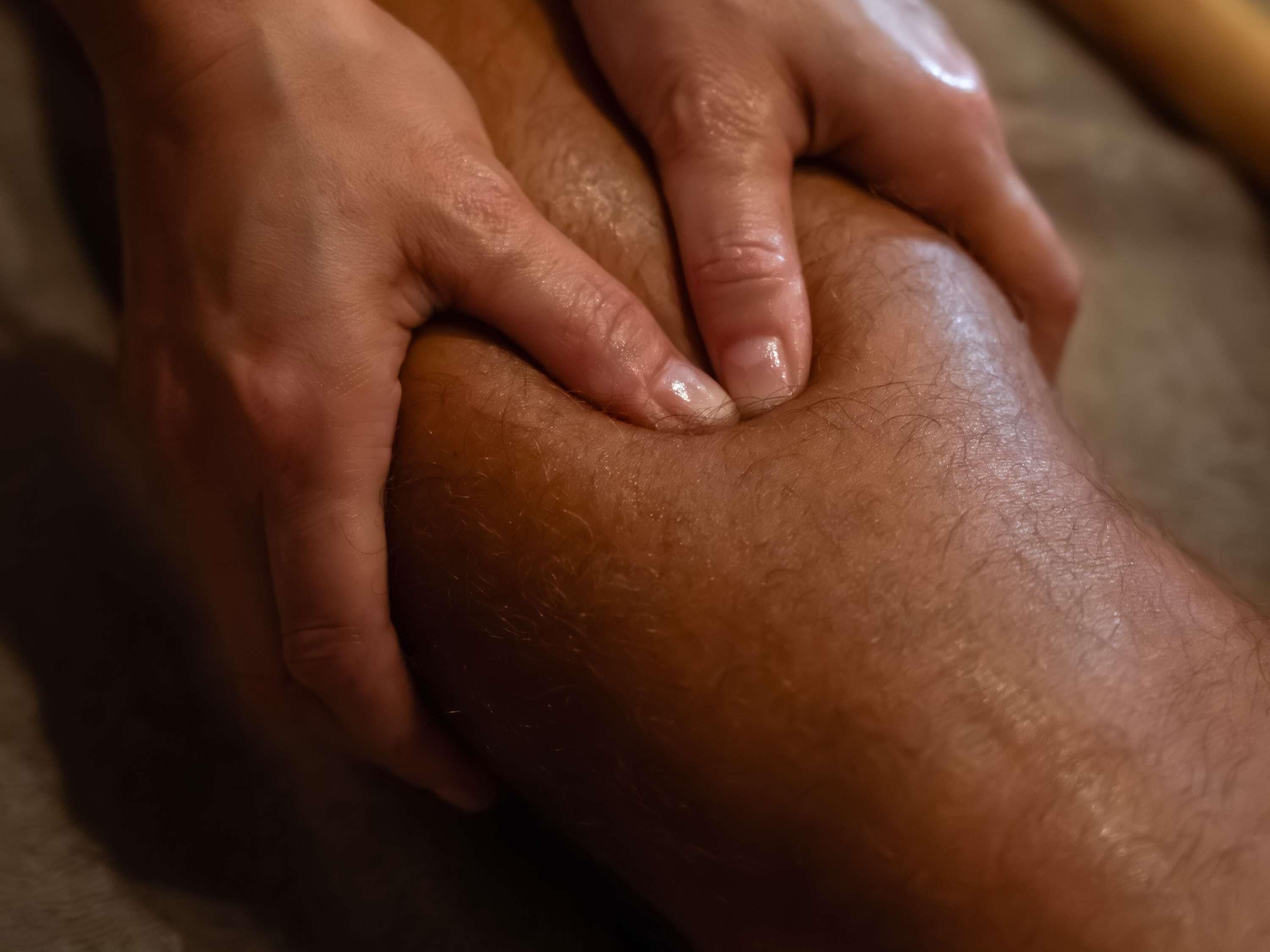 A close-up of hands holding a knee.