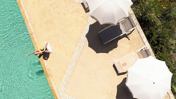 Een buitenzwembad, parasols voor strand/zwembad