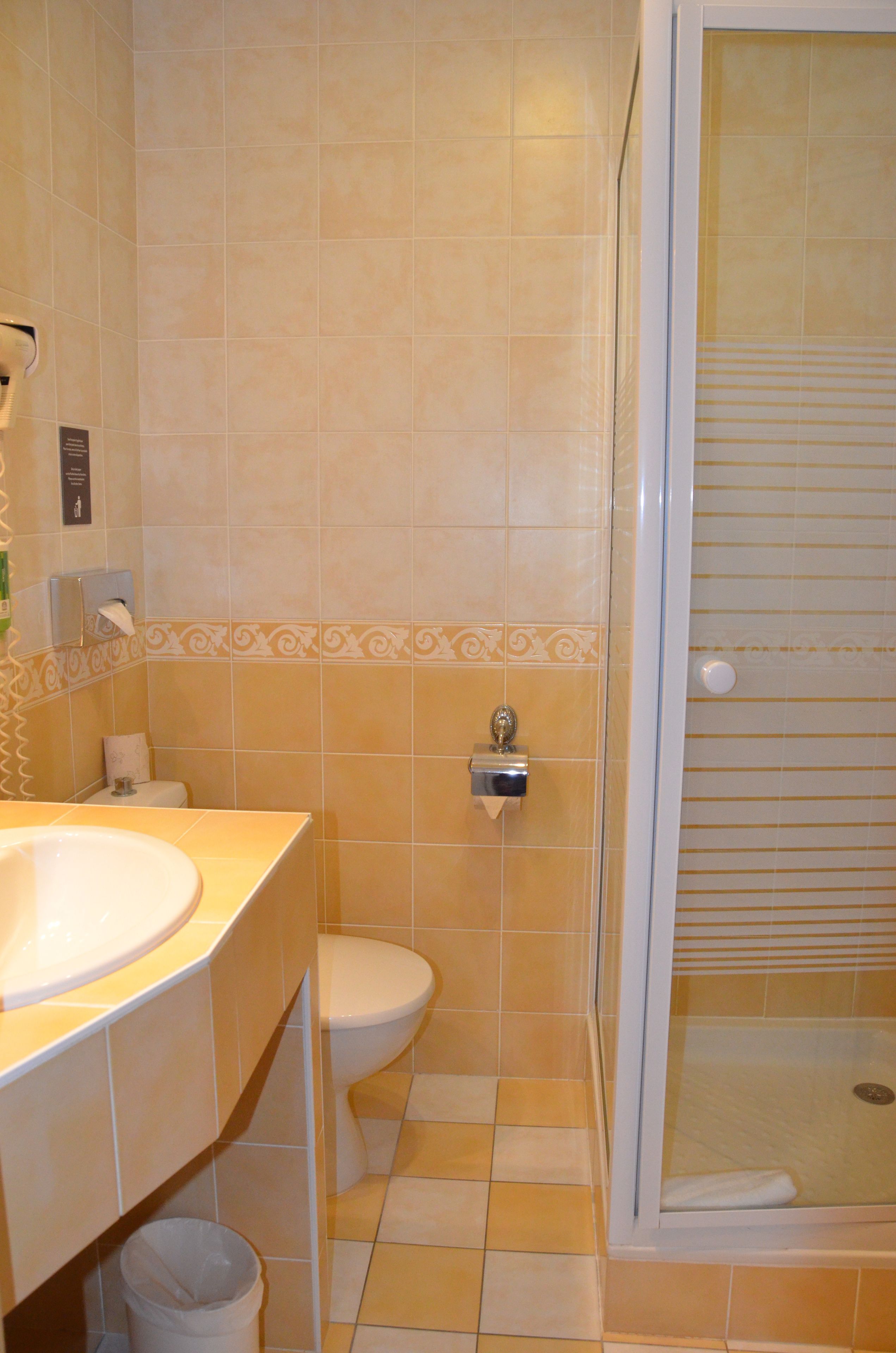 A bathroom with a sink, toilet, and shower.