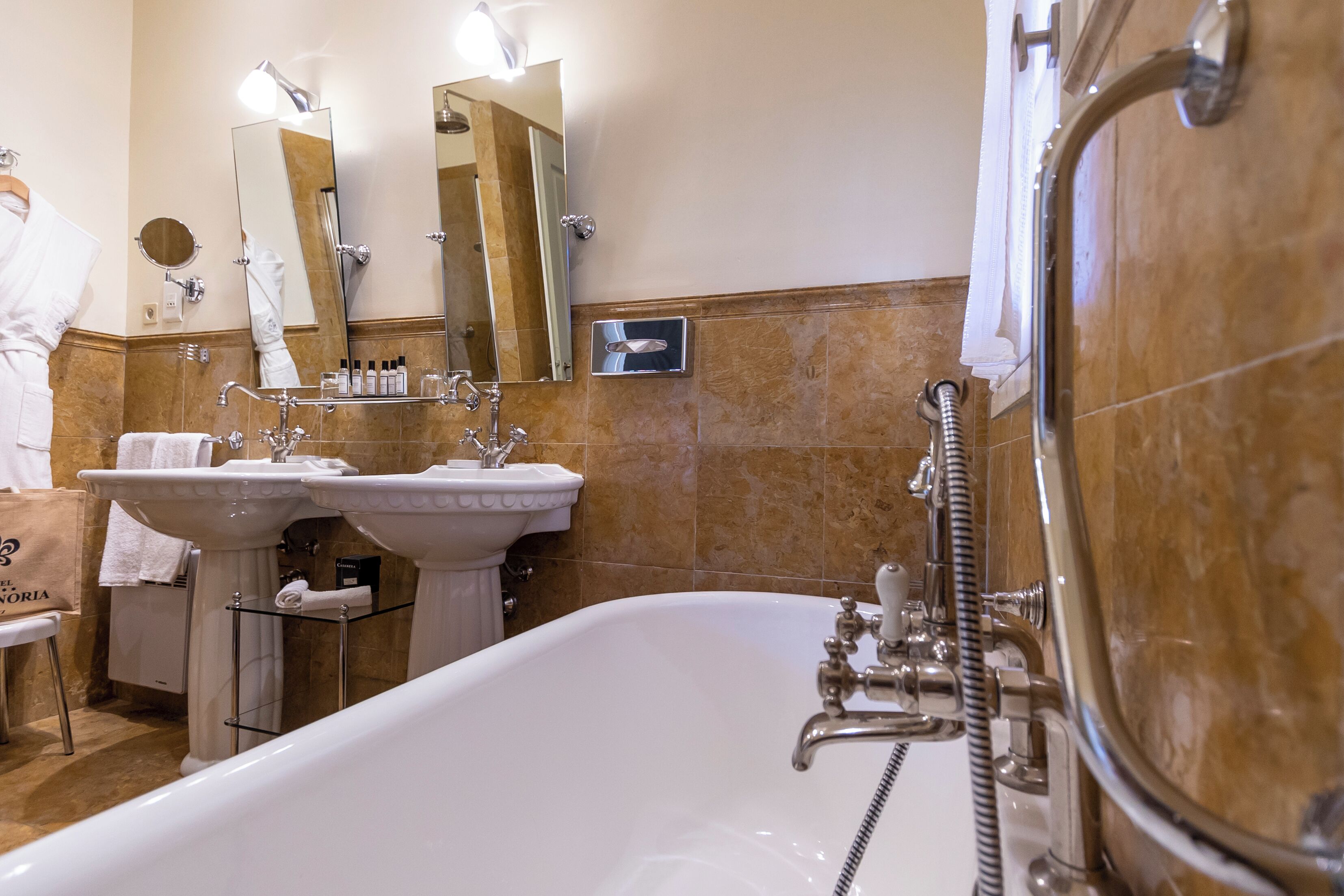 Une salle de bain avec deux lavabos, une baignoire et une douche.
