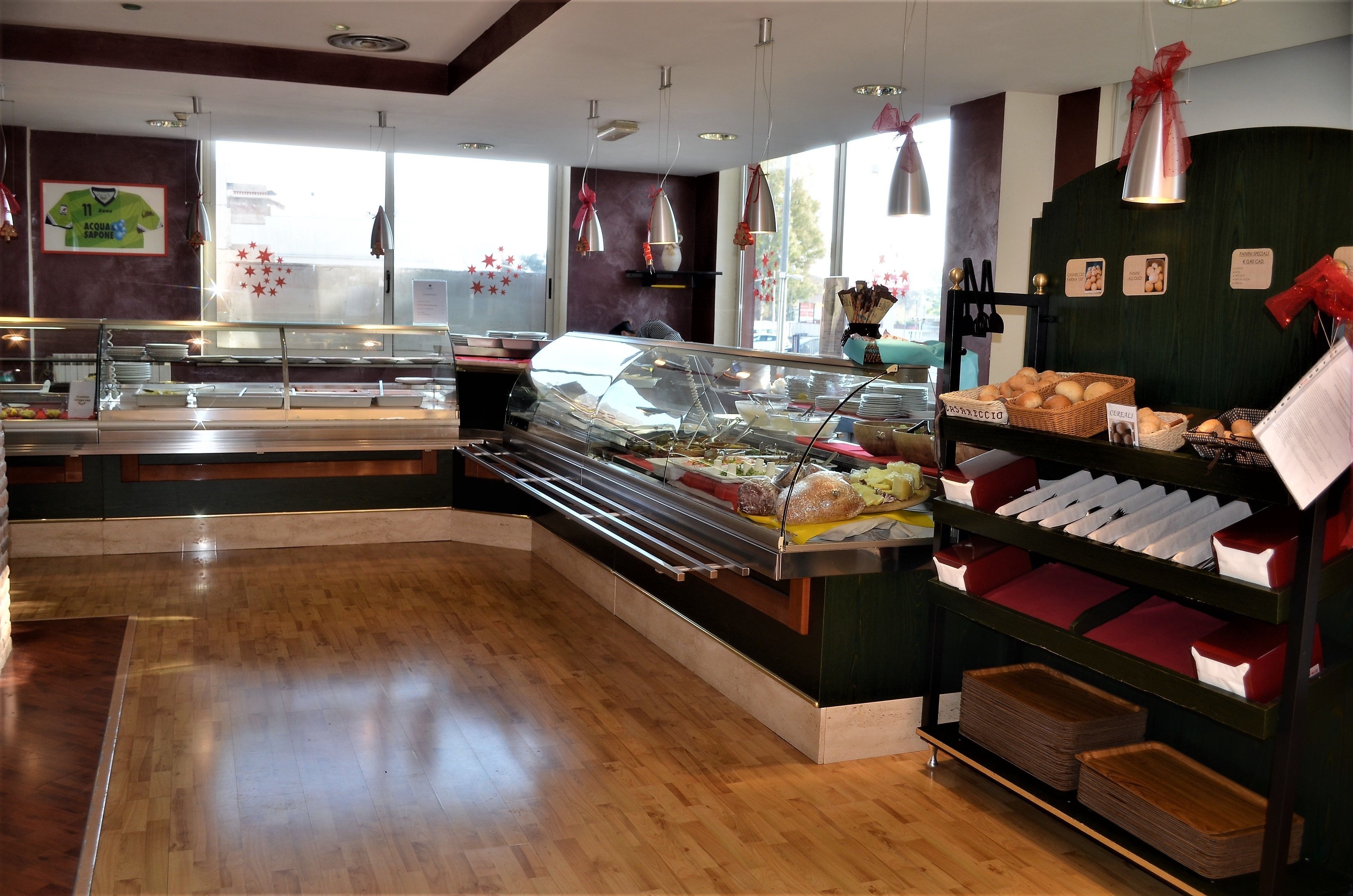 A buffet area with a variety of food items, a glass display case, and a counter with bread and pastries.