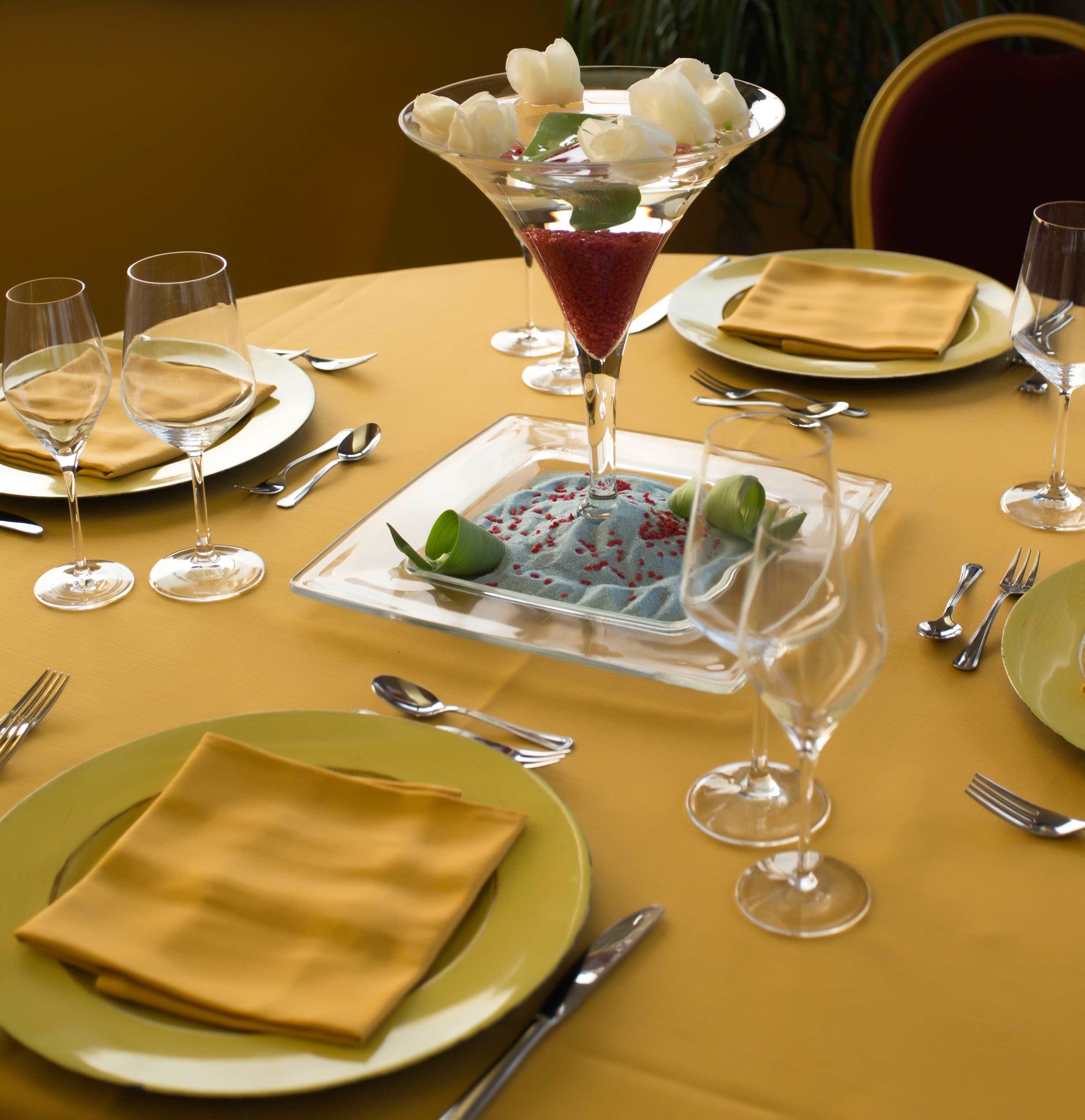 A formal dining table set with plates, cutlery, and a martini glass.