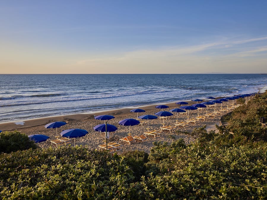 Di pantai, payung pantai, dan handuk pantai