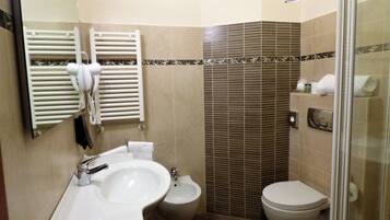 A bathroom with a sink, bidet, toilet, and towel rack.