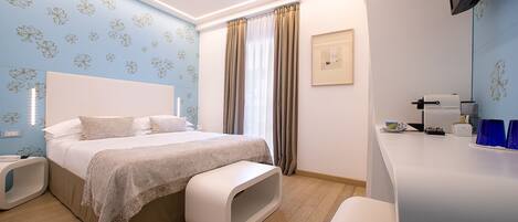 Un dormitorio moderno con una cama grande, mesitas de noche, un escritorio y una ventana con cortinas.
