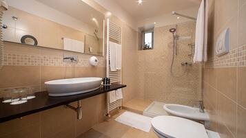 A modern bathroom with a large sink, a separate shower area, and a toilet.
