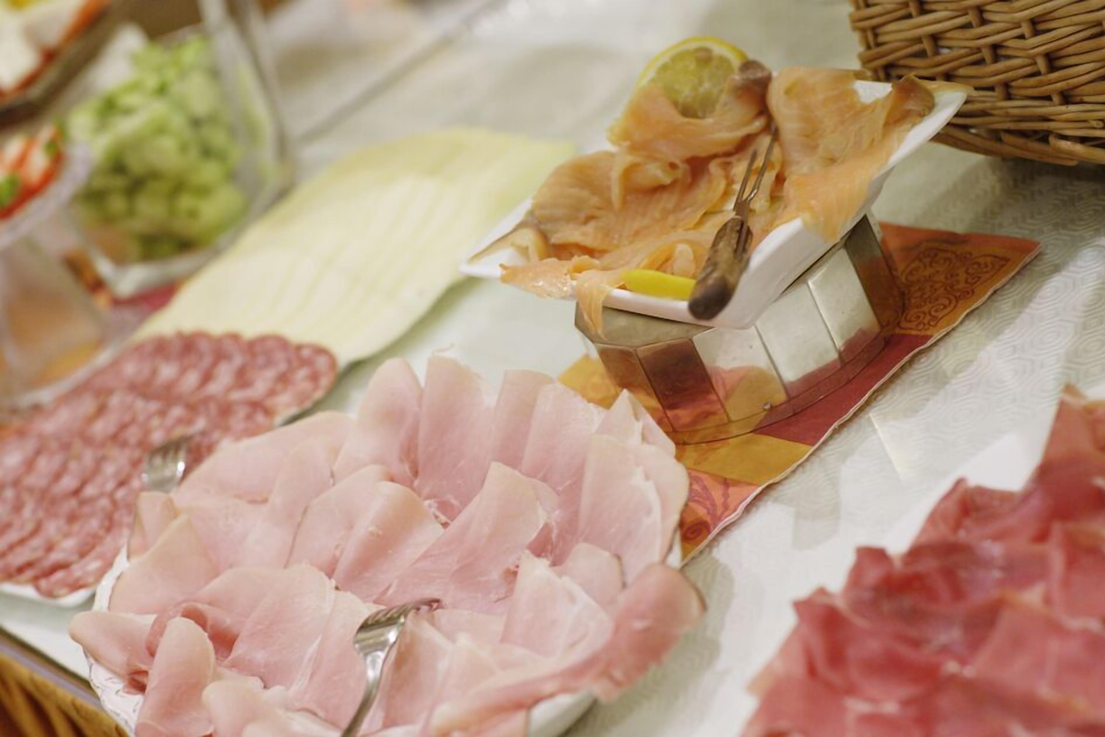 Diversas rebanadas de embutidos sobre una mesa, incluyendo jamón y salami.