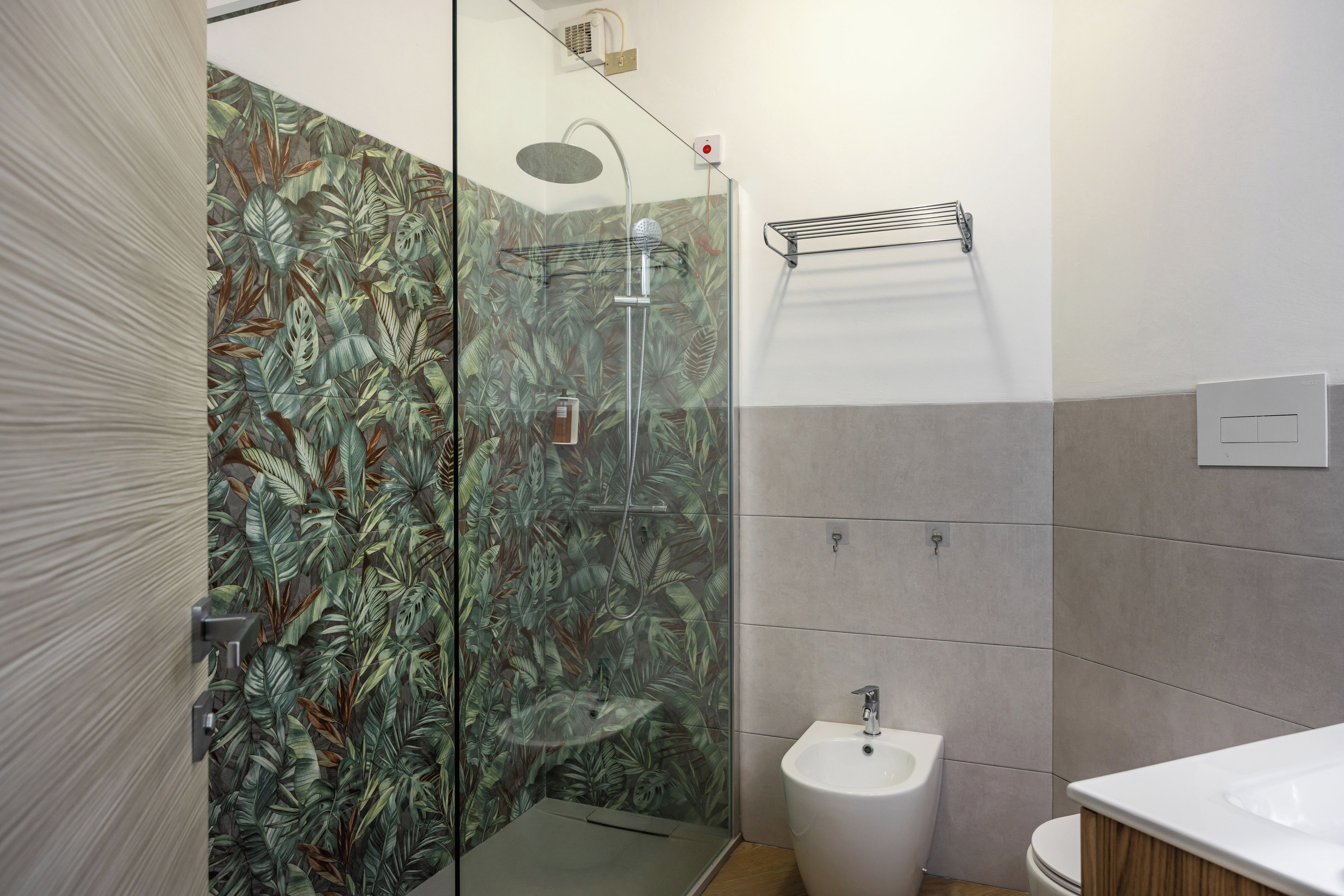 A bathroom with a shower, bidet, and toilet.
