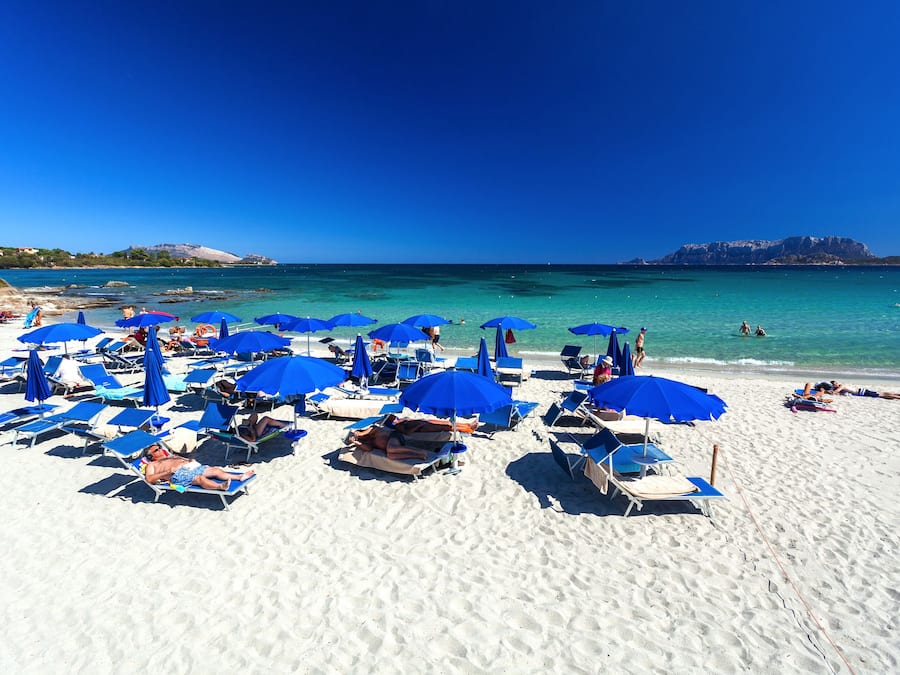 On the beach, white sand, sun-loungers, beach umbrellas