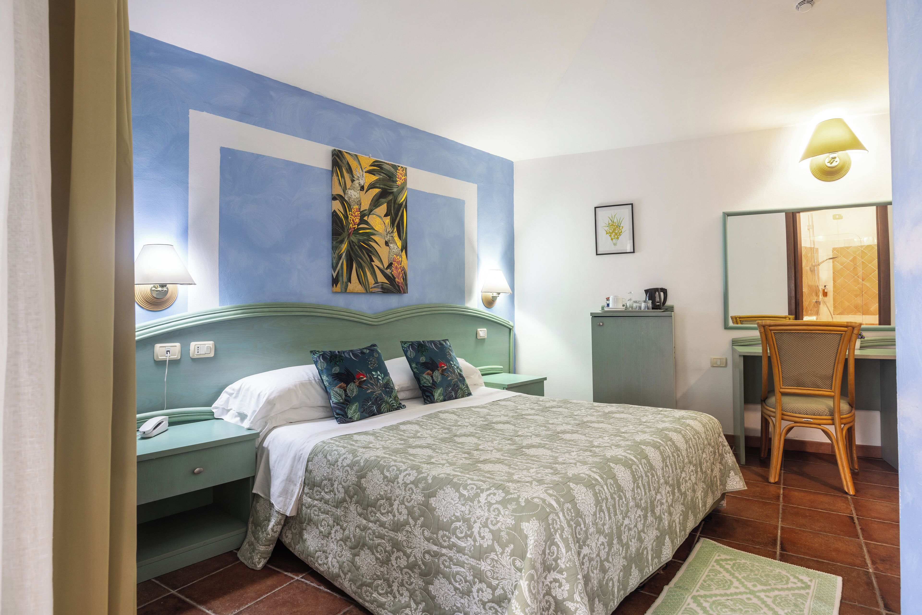 A bedroom with a bed, nightstands, a desk, and a chair.