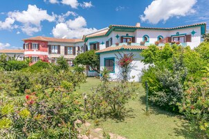 Uma fileira de casas coloridas com um jardim bem cuidado na frente.